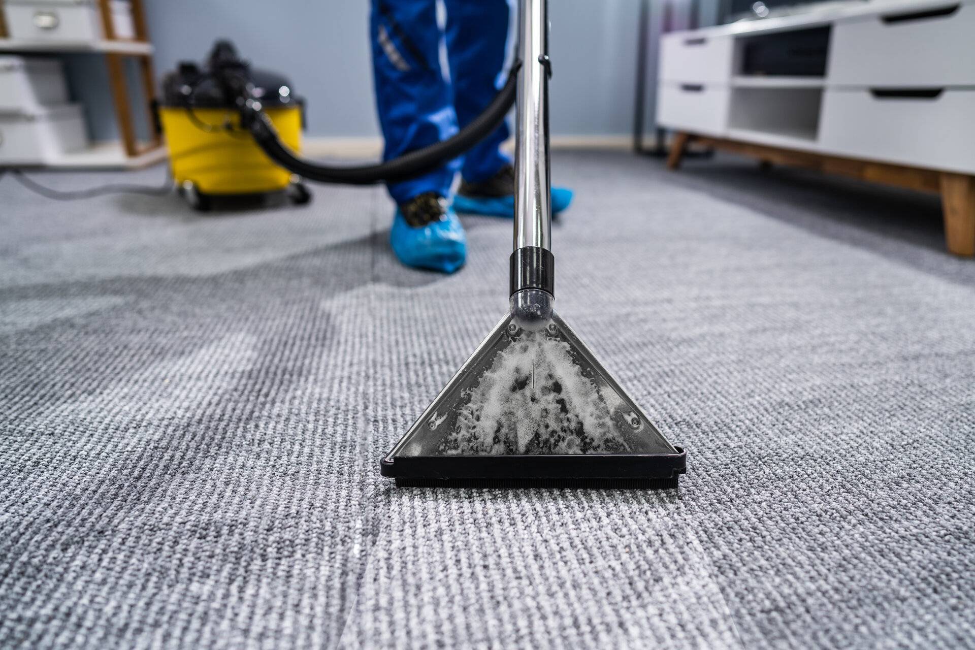 Foto des Hausmeisters, der Teppich mit Staubsauger reinigt