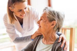 Pflegefachkraft beim Hausbesuch einer Seniorin