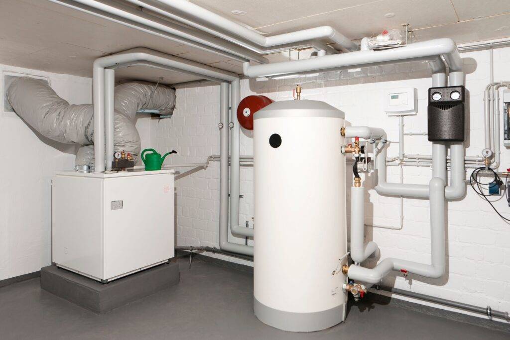 Moderne Heizanlage in einem Keller in Nordrhein-Westfalen, ausgestattet mit einer Ölheizung und einem Warmwasserspeicher, zeigt fortgeschrittene Lösungen zur Reduzierung der Heizkosten in Zeiten steigender Heizölpreise.