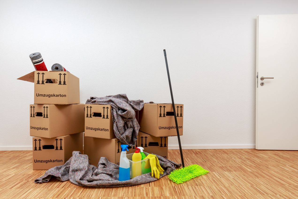 umzugsboxen und putzmittel nach abgeschlossener entrümpelung neuss in leerem zimmer