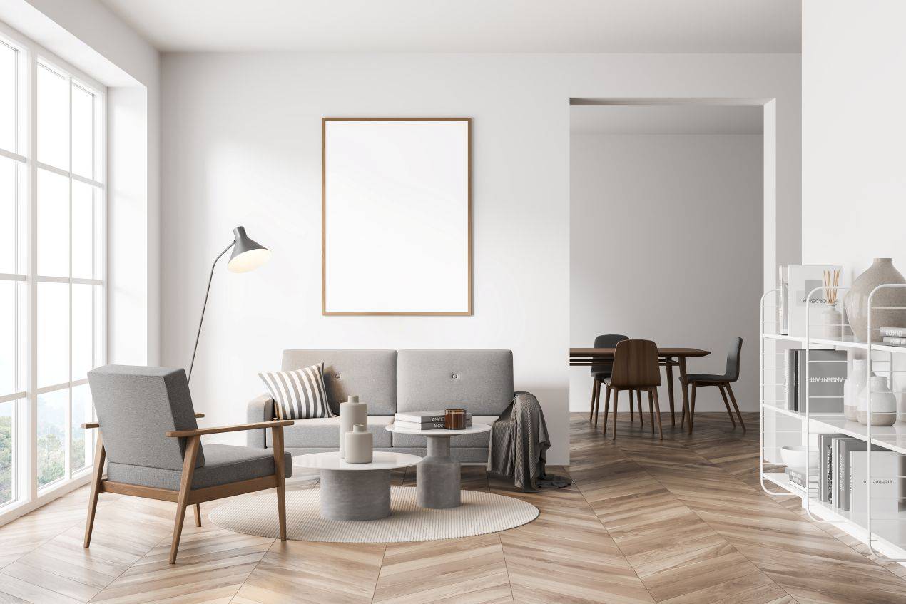Helles Wohnzimmer mit grauem Sofa, Holzlaminat und minimalistischem Einrichtungsstil – optimale Umgebung fuer ein integriertes Akustikpaneel