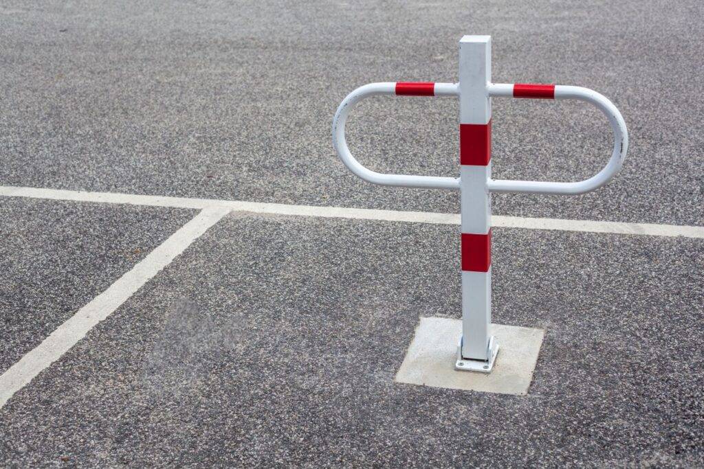 montierte parkplatzsperre auf leerem stellplatz als technische loesung gegen unbefugtes parken