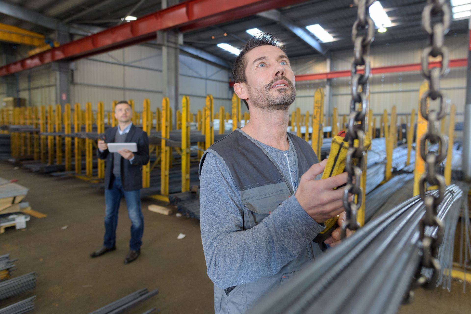 Techniker bedient Kettenzug in moderner Werkhalle